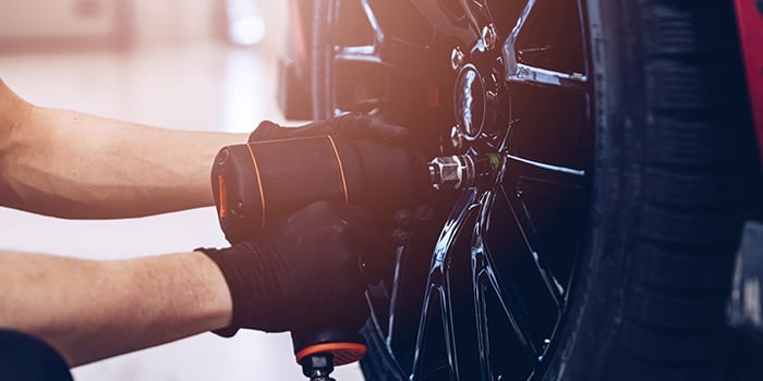 Close up shot of a technician reinstalling a tire